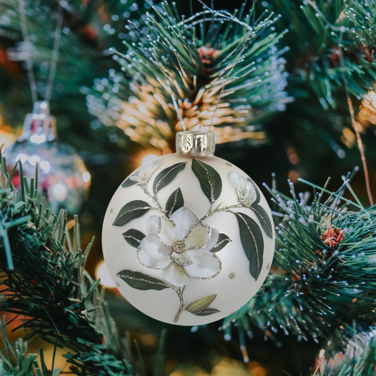 Gisela Graham Matt Cream Magnolia Glass Christmas Bauble  This Gisela Graham Matt Cream Magnolia Glass Christmas Bauble is perfect for decorating your tree this holiday season. Its smooth matt cream finish gives the perfect wintery touch and the intricate magnolia design adds a hint of nature for a truly unique look.