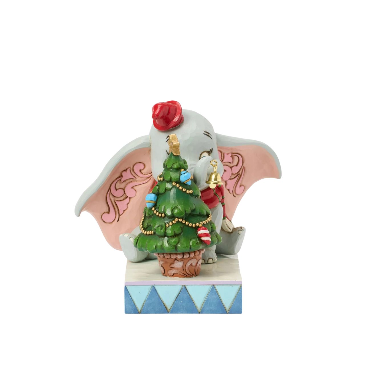 In this heartwarming Jim Shore scene, Dumbo is festively dressed in a red coat and hat as he joyfully decorates a miniature Christmas tree with a real working bell in his trunk. Capture the spirit of the season with Dumbo's playful spirit.