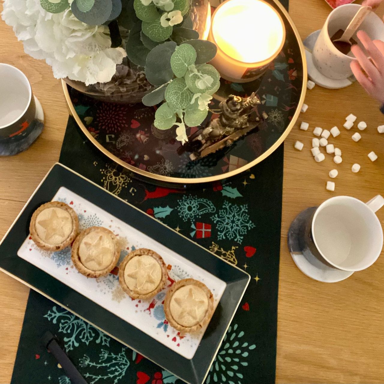Christmas Wish Table Runner by Mindy Brownes Interiors  A beautiful table runner finished in forest green with a Christmas design that depicts some of Christmas' key elements, such as reindeer, presents, music notes, and more.