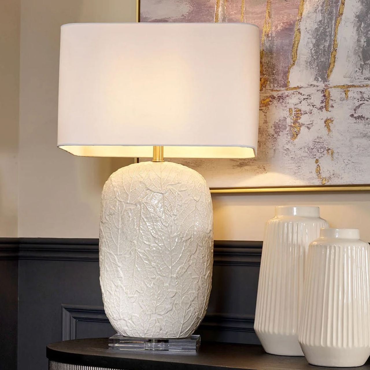 Illuminate your home with our Casla Lamp, featuring a rectangular white crisp shade and leaf pattern base. A truly unique design.