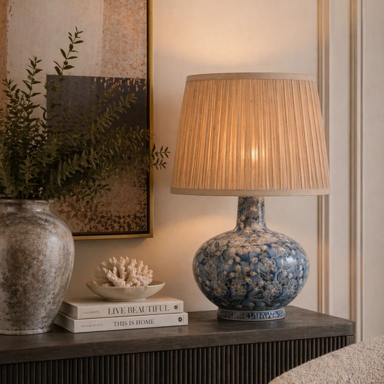 The Cleo Lamp brings timeless elegance with its blue floral ceramic base and softly pleated shade. The intricate pattern adds depth and character, while the neutral shade diffuses a warm, inviting glow, perfect for creating a relaxed atmosphere.