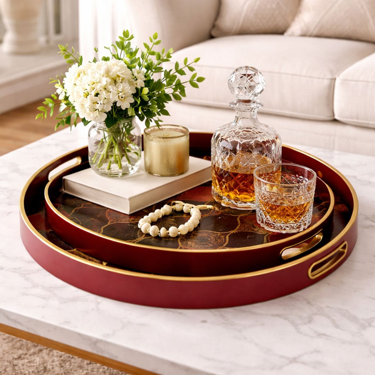 A stunning set of two circular trays, with a rich red surround, gold rim and black interior, finished with a gold pattern and pops of pink and rich red colours.