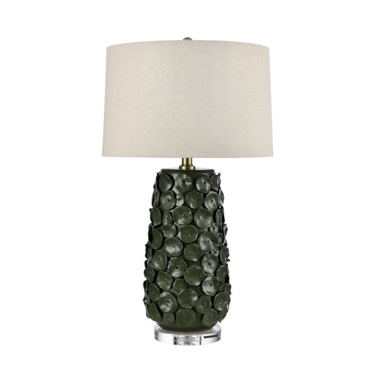 Illuminate your space with our Marin Lamp, featuring a simple shade and a base adorned with a circular pattern reminiscent of lily pods. Deep green in colour.