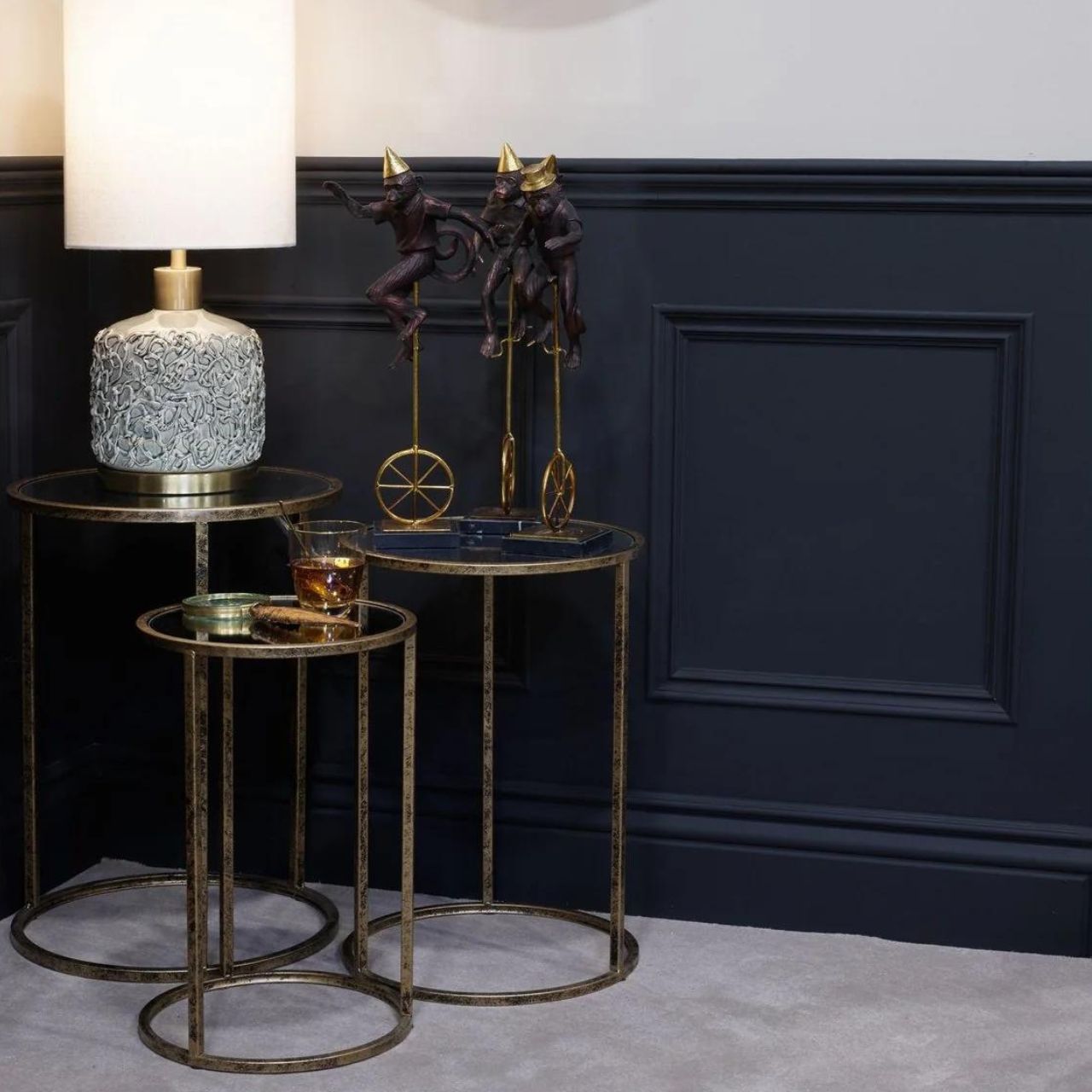 Mindy Brownes Mirror Top Nest of Tables Set of 3  Three Pod Tables that neatly stack on top of one another. Champagne gold colour in finish and a mirror top. A beautiful addition to any home. These tables only stack on top of one another, or side by side, underneath bars should not be crossed. 