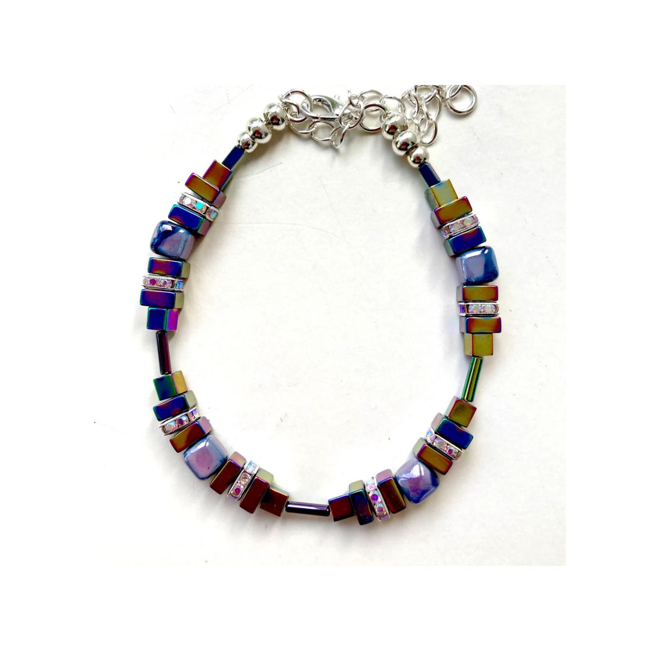 Lilac and white handmade Ceramic Cubes are combined with rainbow hued Hematite gemstone squares and sparkling silver-plated Rhinestone spacers.