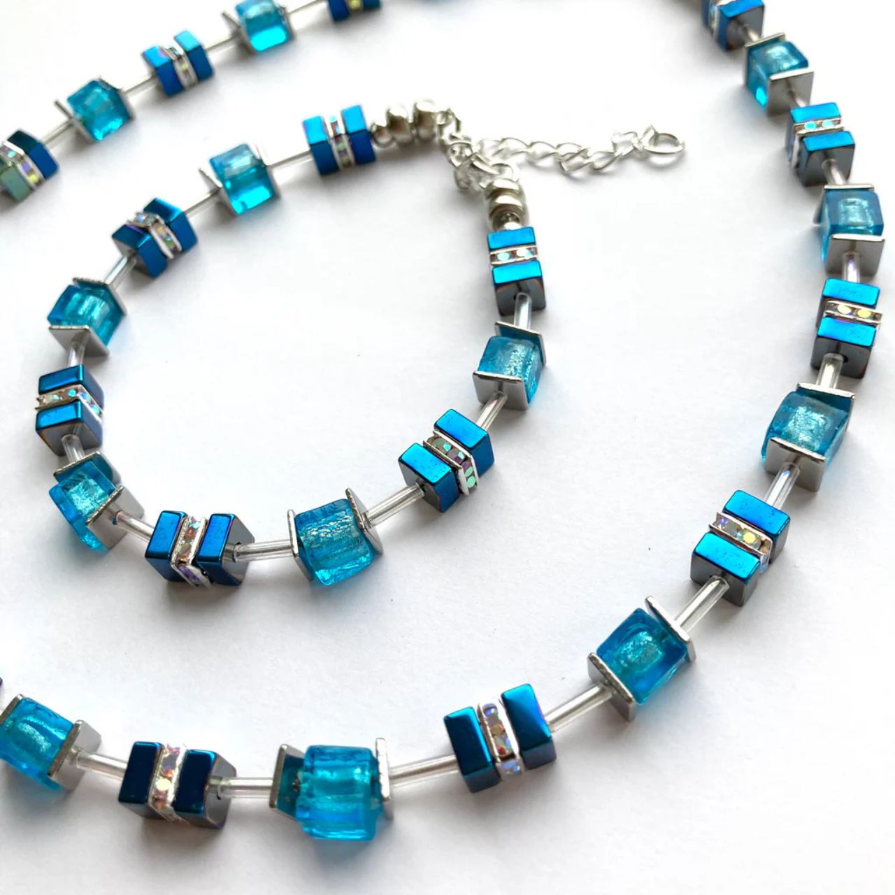 These earrings comes with silver-lined Murano-style glass cubes in ocean blue complemented by Hematite gemstone squares in marine blue with the added sparkle of silver Rhinestone spacer beads.