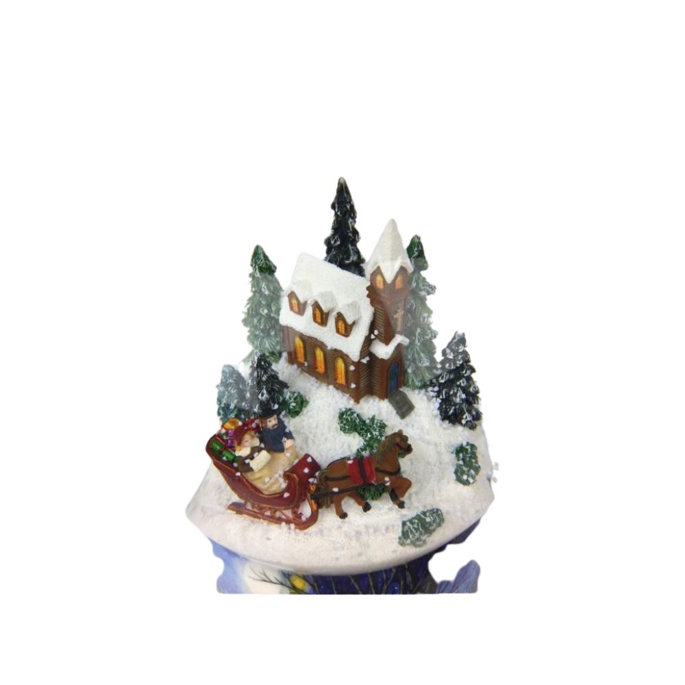 Snow globe sleigh ride. In the globe filled with snow, a couple takes a nostalgic sleigh ride past a snow-covered church surrounded by fir-trees. The base is painted with snowy village scenes. By winding the musical mechanism up, the scene starts to rotate inside the globe to the melody “Jingle Bells”.