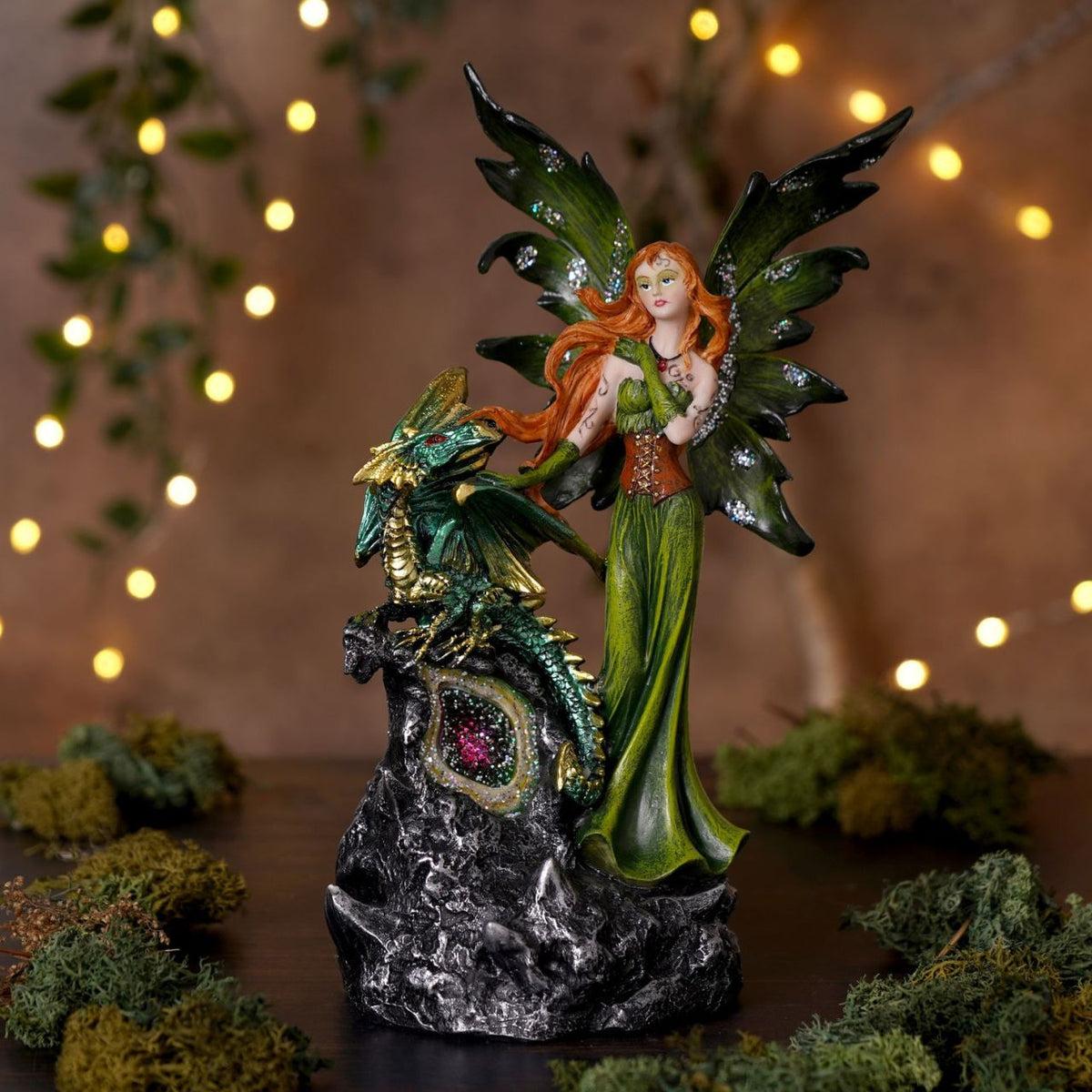 Mystic Legends LED Fairies with Dragon Green & Purple 21cm is a mesmerising pair of fantasy ornaments, designed to bring enchantment and rich colour to any display. Each piece features a beautifully sculpted fairy accompanied by a detailed dragon companion, standing atop a rugged rock-style base that enhances the sense of storytelling and depth.