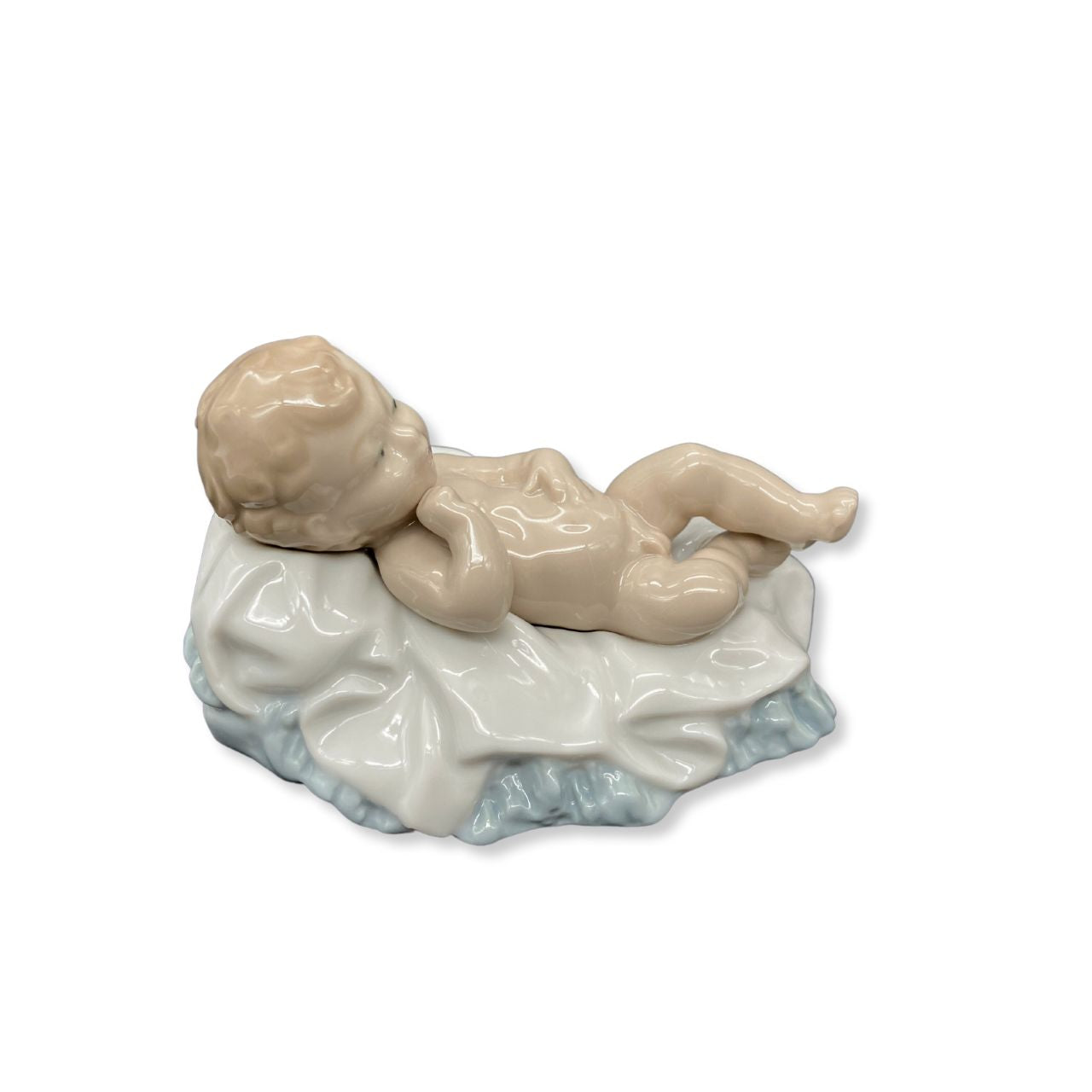 Nao by Lladro Baby Jesus  Nao porcelain figurine “Baby Jesus” from the Christmas Collection.  Sculpted by Salvador Furió, this figurine is part of the nativity set.  Nao Porcelain Figurines are produced in Valencia Spain and the Company is part of the Lladro family. Each piece is lovingly handmade and hand painted by the Valencia Artisans.