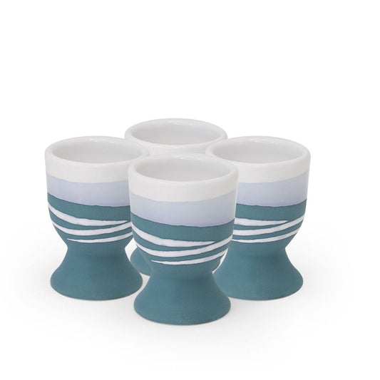 Tipperary Crystal Paul Maloney Pottery Teal Set of 4 Egg Cups  A modern twist on a classic style, this Paul Maloney Pottery Teal Set of 4 Egg Cups adds sophistication to your table settings. Crafted from durable and long-lasting stoneware, these egg cups are made to withstand the test of time and will be a staple of your kitchenware for years to come. Perfect for your morning eggs, they're sure to be a welcome addition to any kitchen.