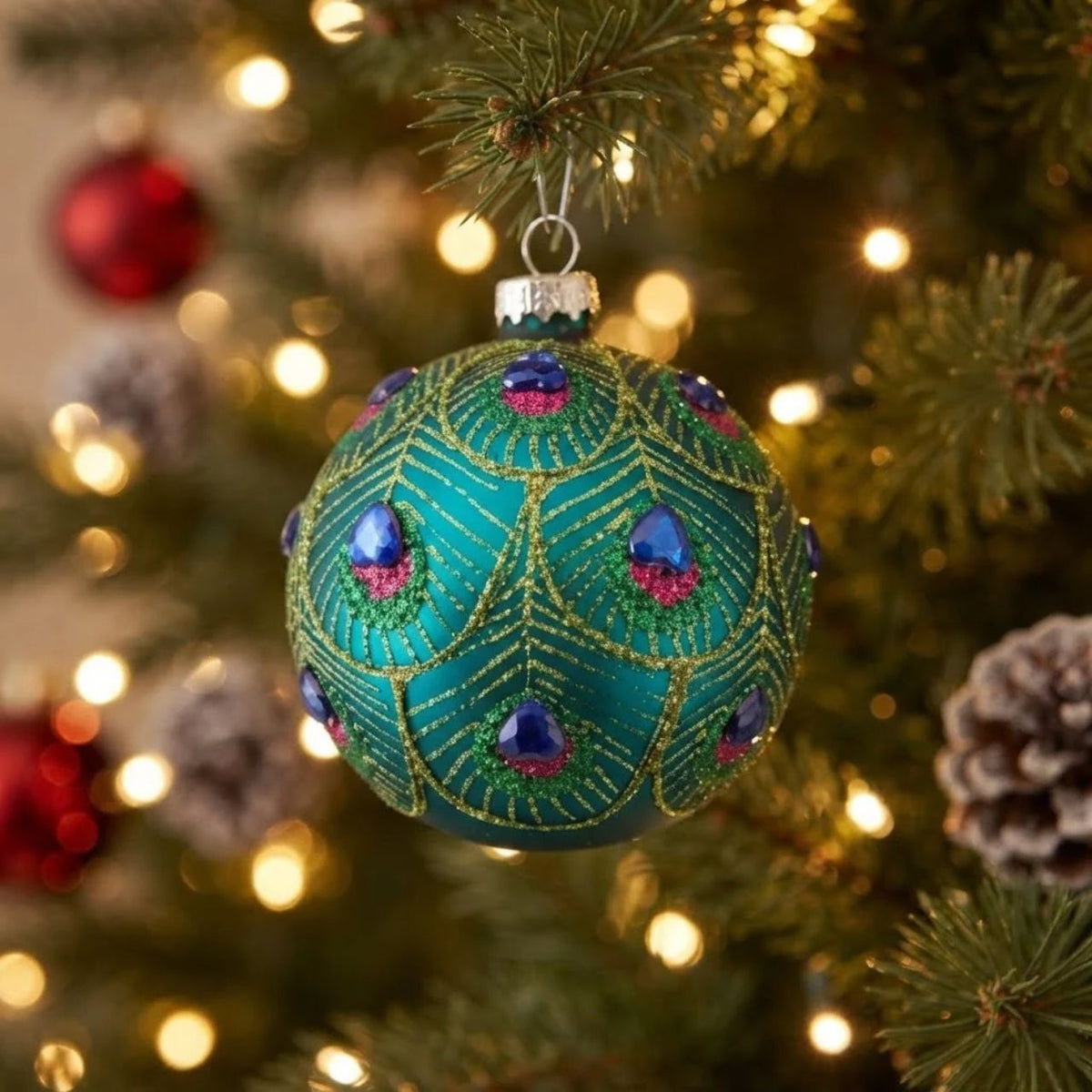 Elevate your festive décor with this stunning peacock feather-inspired glass bauble. Featuring an elegant scalloped design and iridescent peacock detailing, this ornament brings sophisticated holiday charm to any tree or display.