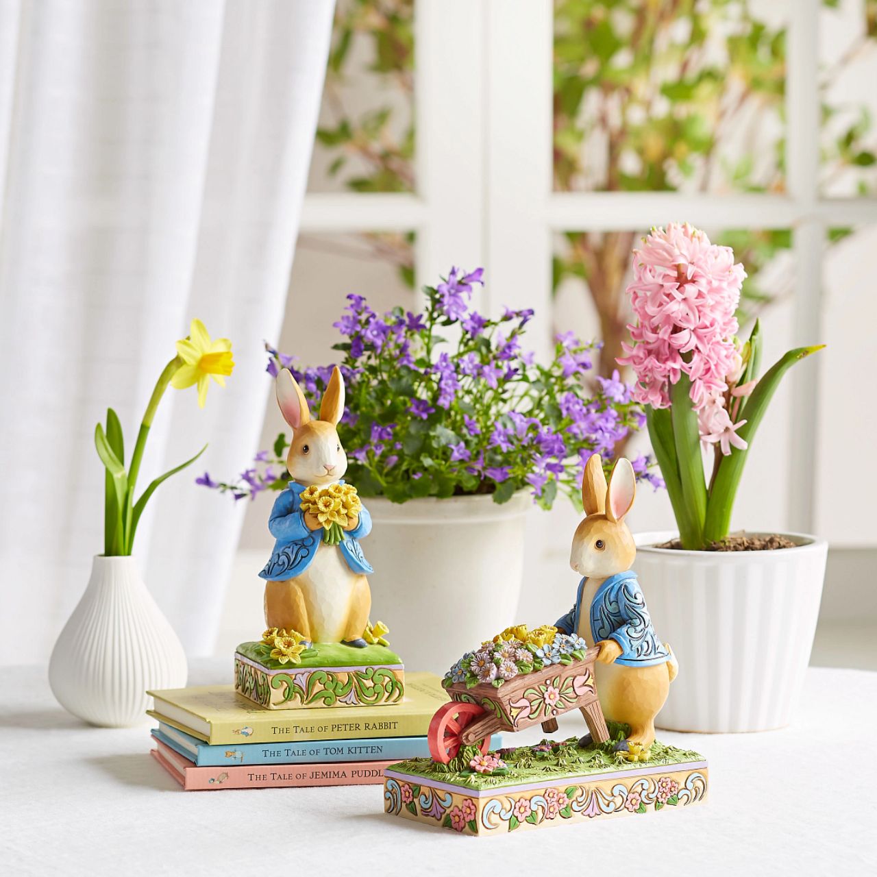 Peter Rabbit with Daffodils - Wearing his signature blue coat, Peter Rabbit blushes as he presents a bouquet of daffodils picked for you in this sweet design. Styled by Jim Shore, Peter's coat boasts rosemale petals as he stands on a decorated stage of springtime growth.