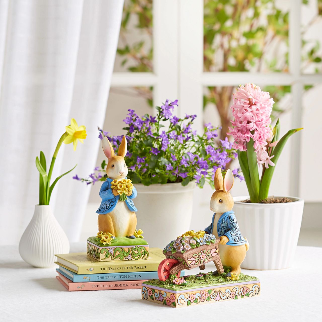 Peter Rabbit with Wheelbarrow of Flowers - Wearing his signature blue coat, Peter Rabbit pushes a wheelbarrow full of inviting flowers in this beautiful creation. Designed by Jim Shore, this creation features a wealth of inspired rosemale details, enchanting craftsmanship, and cheerful colour.