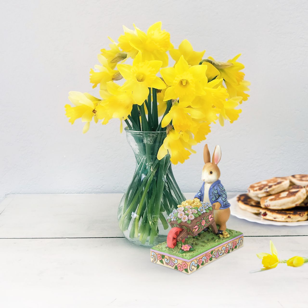 Peter Rabbit with Wheelbarrow of Flowers - Wearing his signature blue coat, Peter Rabbit pushes a wheelbarrow full of inviting flowers in this beautiful creation. Designed by Jim Shore, this creation features a wealth of inspired rosemale details, enchanting craftsmanship, and cheerful colour.