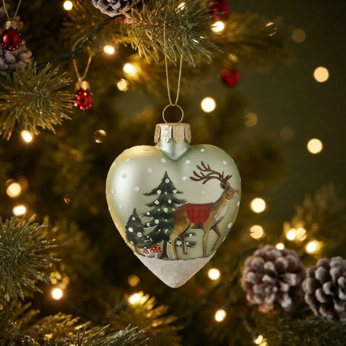 Charming heart-shaped glass ornament from Gisela Graham's festive collection. Features a cheerful plaid animal design perfect for adding personality to your Christmas tree. Handcrafted glass construction ensures durability and a beautiful sparkle when light catches it.