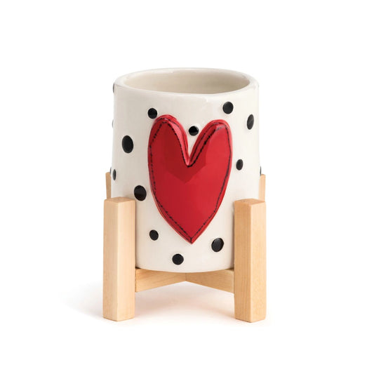 Tracy Pesche's Red Heart Mini Planter  Add a whimsical, happy touch to your home with Tracy Pesche's uplifting ceramic art. Her hand-painted Red Heart Mini Planter is a white planter with black polka dots and a bold red heart.