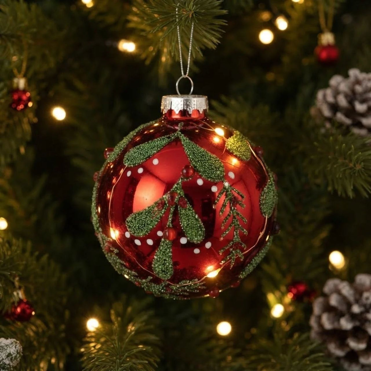 Elevate your festive décor with this elegant Gisela Graham Christmas bauble. Featuring a striking red mirrored finish complemented by delicate beaded green vine detailing, this hand-crafted ornament brings sophisticated holiday charm to any tree.