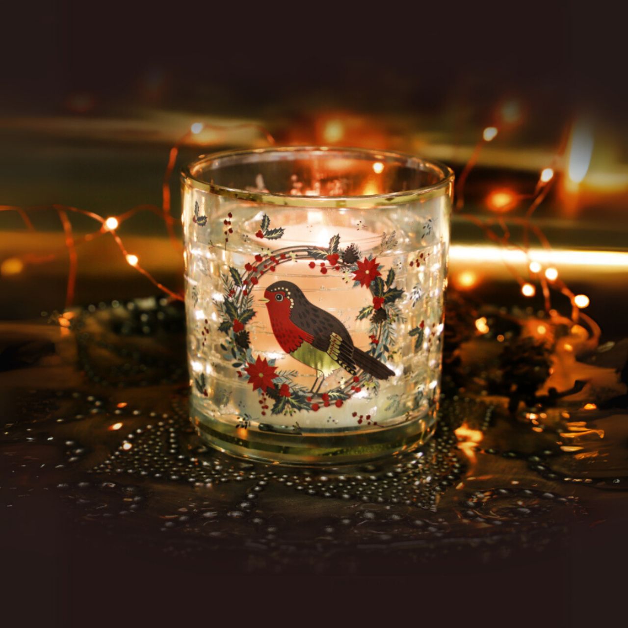 Illuminate your holiday décor with the Tipperary Robin Wreath Christmas LED Light Up Candle. Featuring a delicate robin perched on a festive wreath, this elegant candle offers a warm, ambient glow.
