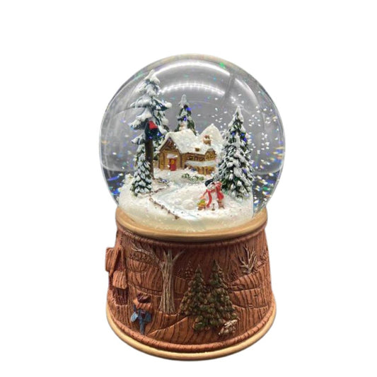 Snow globe made of poly stone. In the 100 mm globe is a small, snow-covered house hidden between snowy hills and fir trees. Next to it are two small children building a snowman.