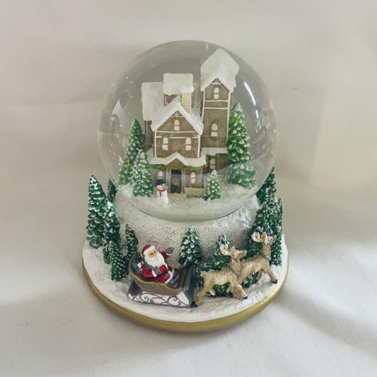 Capture the enchantment of the holiday season with the Snow Globe Green Christmas Countryside. Featuring a serene countryside scene complete with trees and Santa in his sleigh at the base.