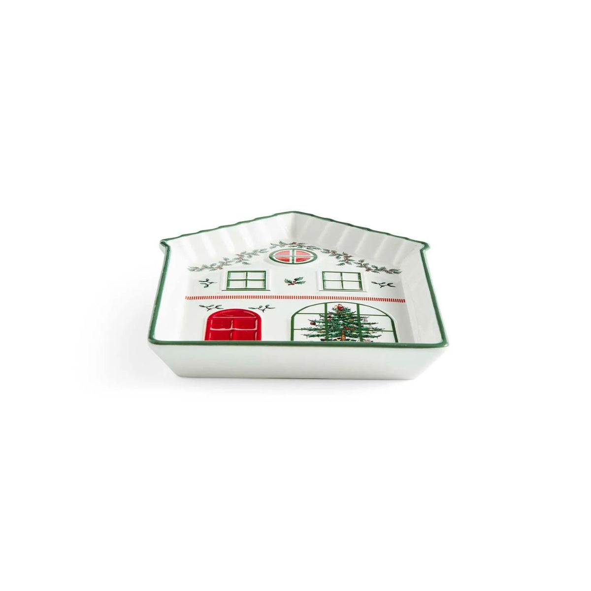 A small white ceramic house-shaped dish with green trim and a holiday-themed illustration featuring a red door, window, Christmas tree, and holly leaves, shown on a white background.