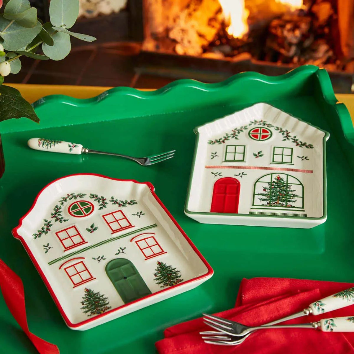 This charming ceramic tidbit tray from Spode is shaped like the front of a delightfully festive house, perfect for adding a touch of holiday charm to your table. The house features a welcoming green door flanked by two charming Christmas trees, inviting red windows, and a delightful display of festive foliage.