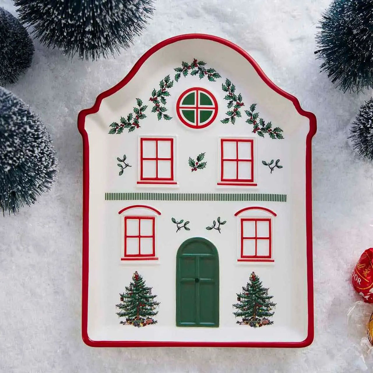 This Christmas Tree Village Tidbit Tray is shaped like a front of a delightful house, adding a touch of festive whimsy to your holiday table.