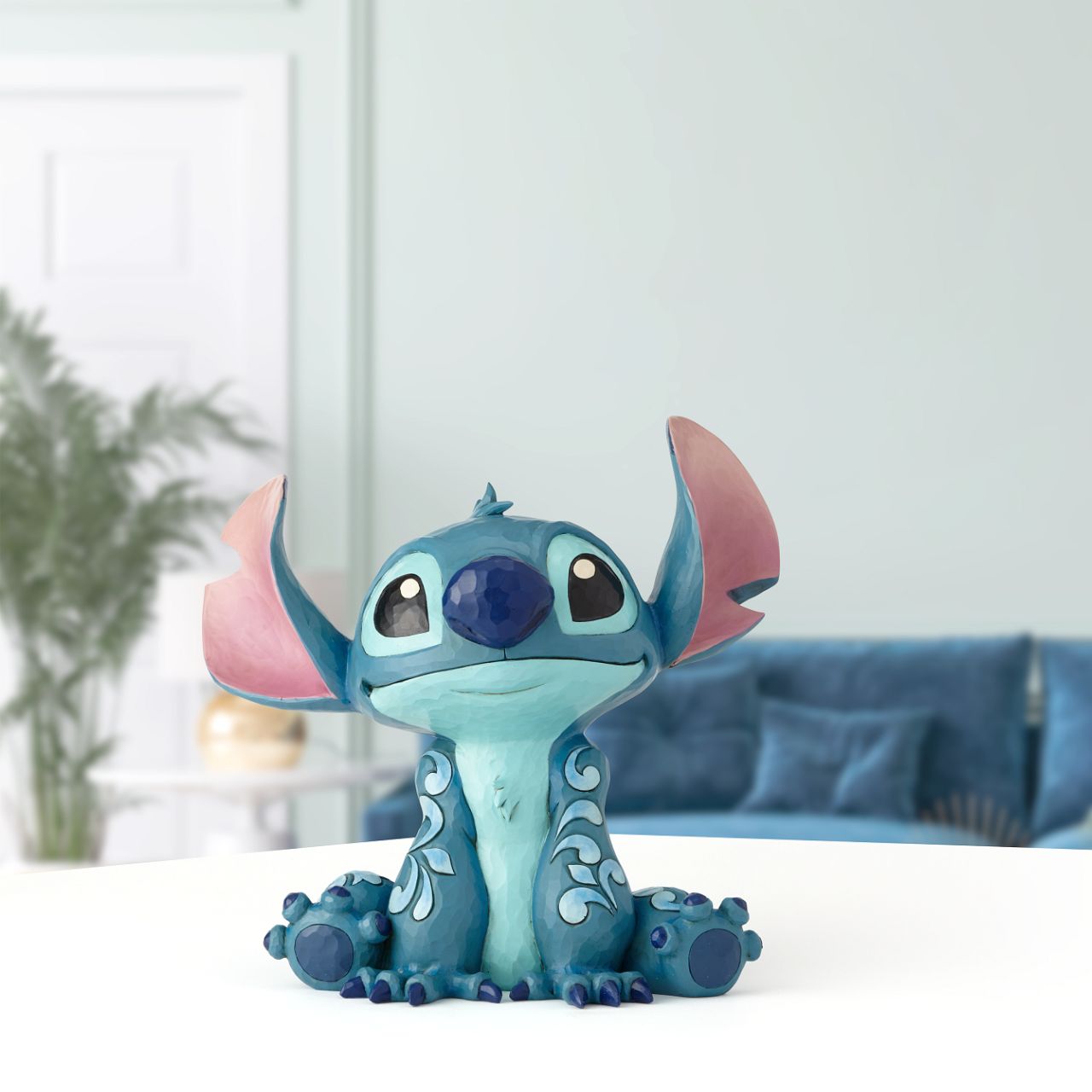Disney Traditions Big Trouble Stitch Statement Figurine  It's hard to believe this sweet face could be behind so much chaos| Stitch, the troublesome alien from Disney's "Lilo and Stitch" strikes an innocent pose in this handcrafted design, sculpted from cast stone and hand-painted with whimsical folk-art details.