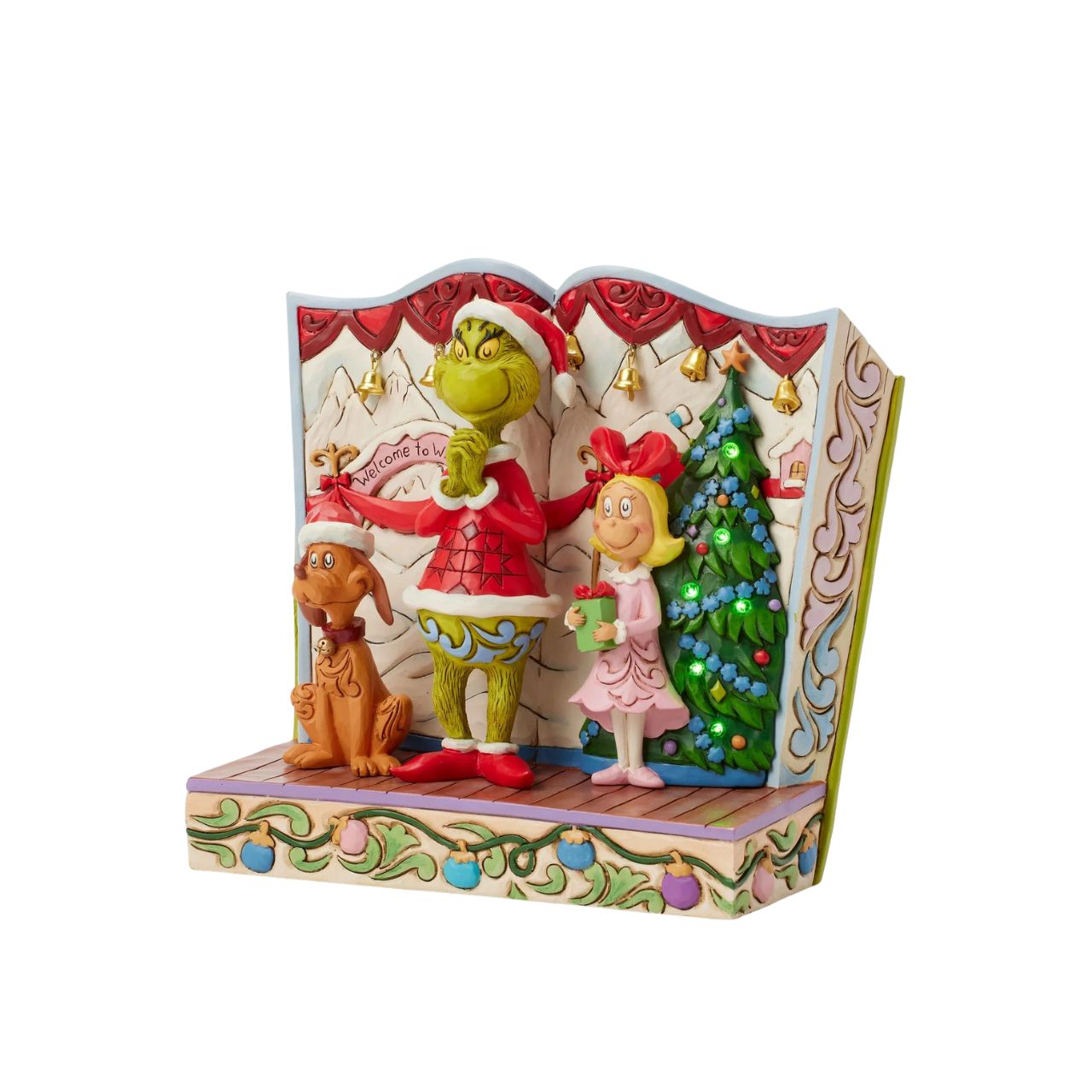 Framed within the classic Dr. Seuss book, this Jim Shore piece captures The Grinch's heartwarming transformation with Cindy Lou and Max by his side. Dressed as Santa, he smiles with rosemaling, patchwork patterns, and real jingle bell details.