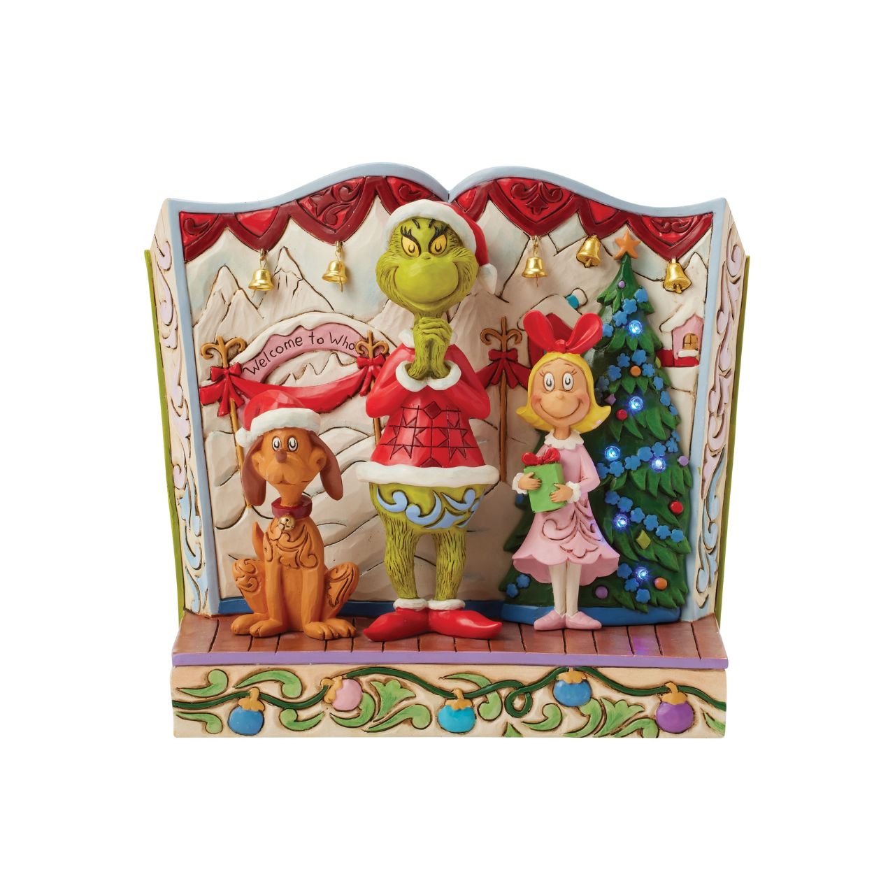 Framed within the classic Dr. Seuss book, this Jim Shore piece captures The Grinch's heartwarming transformation with Cindy Lou and Max by his side. Dressed as Santa, he smiles with rosemaling, patchwork patterns, and real jingle bell details.