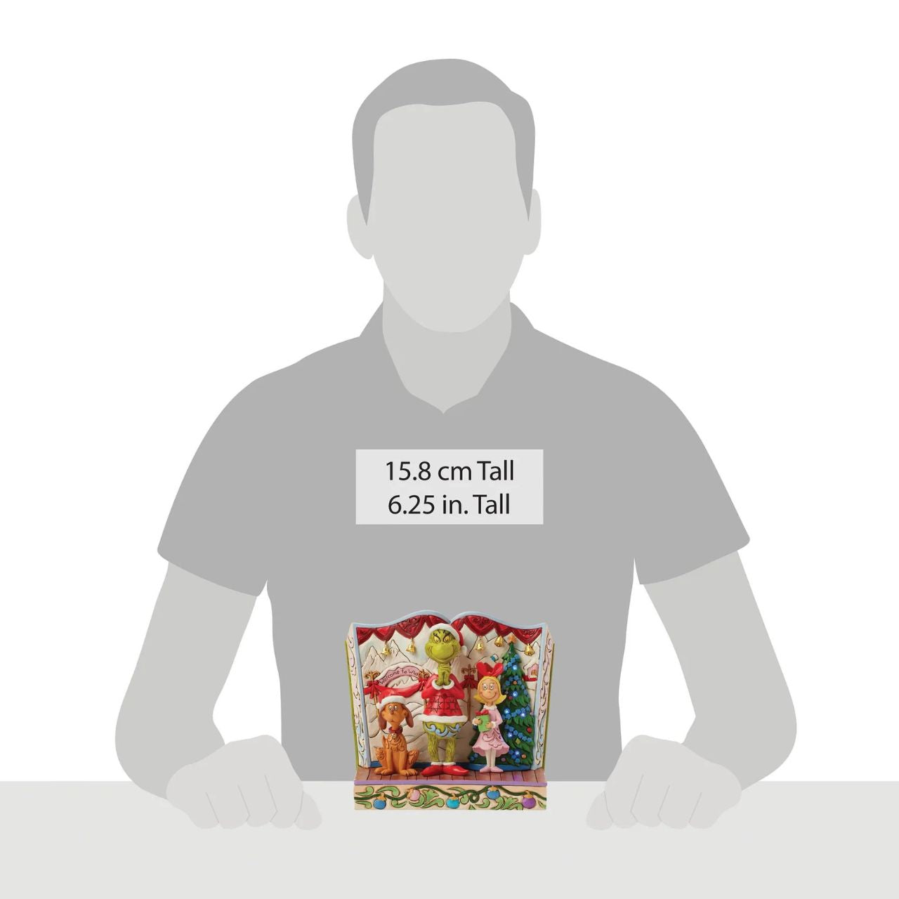 Framed within the classic Dr. Seuss book, this Jim Shore piece captures The Grinch's heartwarming transformation with Cindy Lou and Max by his side. Dressed as Santa, he smiles with rosemaling, patchwork patterns, and real jingle bell details.