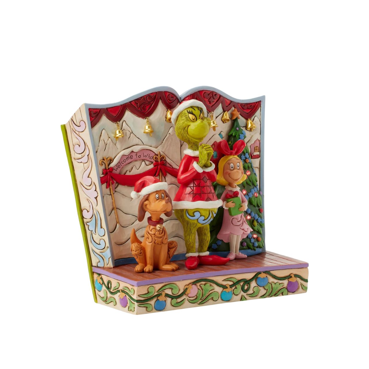 Framed within the classic Dr. Seuss book, this Jim Shore piece captures The Grinch's heartwarming transformation with Cindy Lou and Max by his side. Dressed as Santa, he smiles with rosemaling, patchwork patterns, and real jingle bell details.