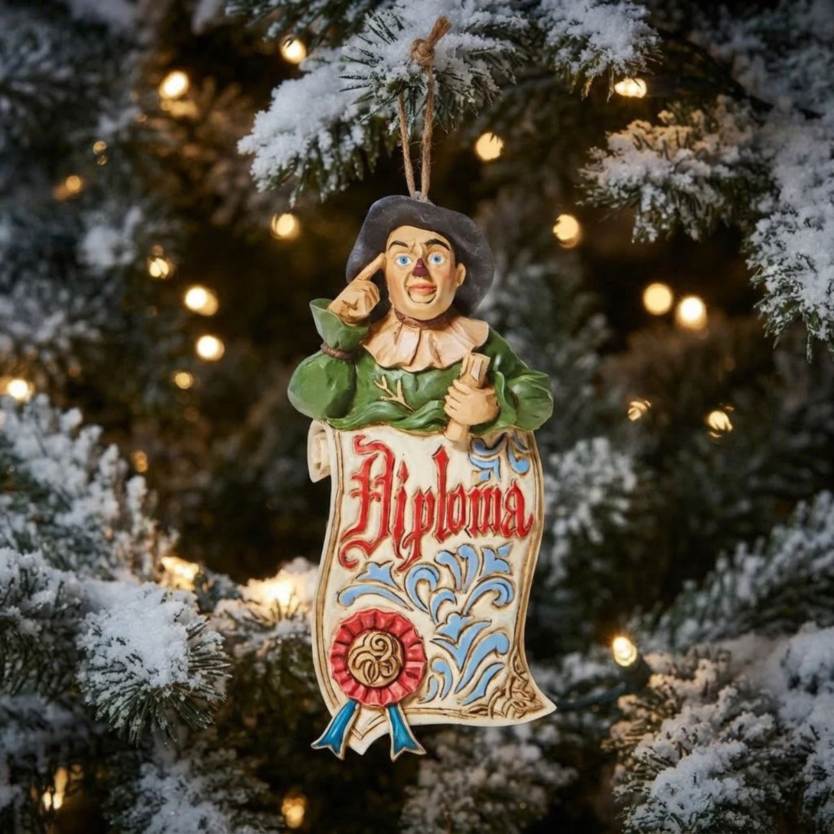 With a knowing tap to his head, an accomplished Scarecrow smiles from your tree. With a ribbon stamped diploma, it looks like this yellow brick road commuter finally got his wish this season. Always a confidant, he finally has a brain to back him up!