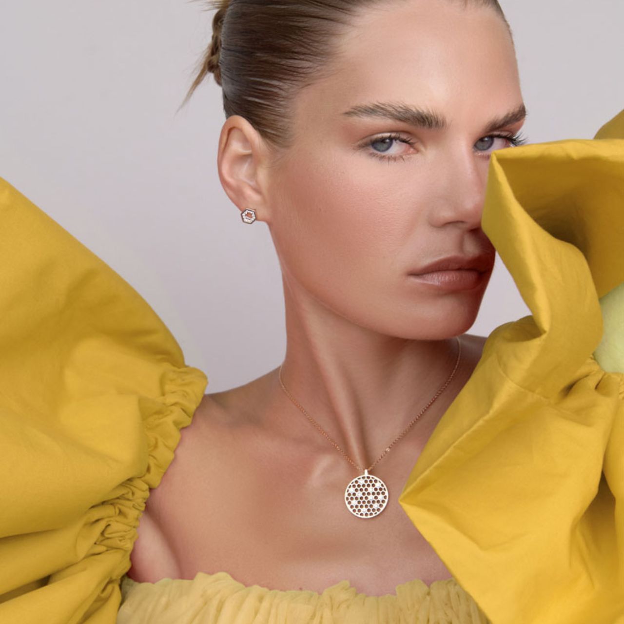 A Honeycomb inspired design with Hexagon shapes within a circular pendant and embelleshed with crystals. A dainty Hexagonal feature with crystals on the chain and finished with a crystal closure feature.