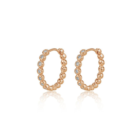 Elegant circle hoop huggies crafted with lustrous gold finish and adorned with sparkling cubic zirconia stones.