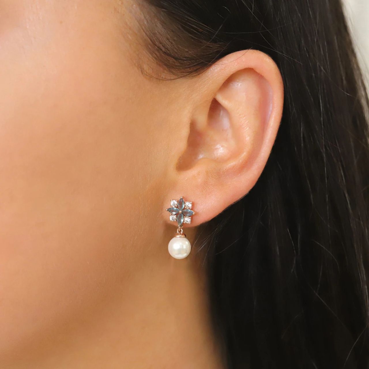 These elegant pearl and crystal post earrings are a captivating look. Fashioned in elegant Rose gold each shimmering earring highlights a luminous pearl topped by an art deco inspired arrangement of 4 dolphin grey marquise shape and round clear CZs.