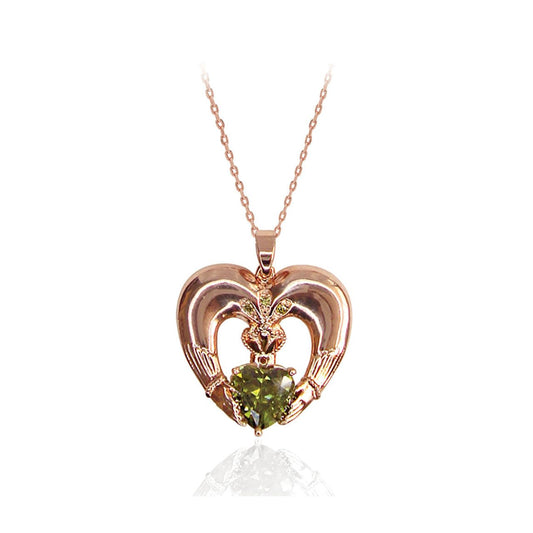 Maureen O'Hara Rose Gold Claddagh Pendant by Tipperary  Celebrating love, loyalty and friendship, this heart-shaped Claddagh pendant shimmers. An emerald green heart-shaped stone is set at the center and adorned with a shimmering crown with three green crystal stone accents.