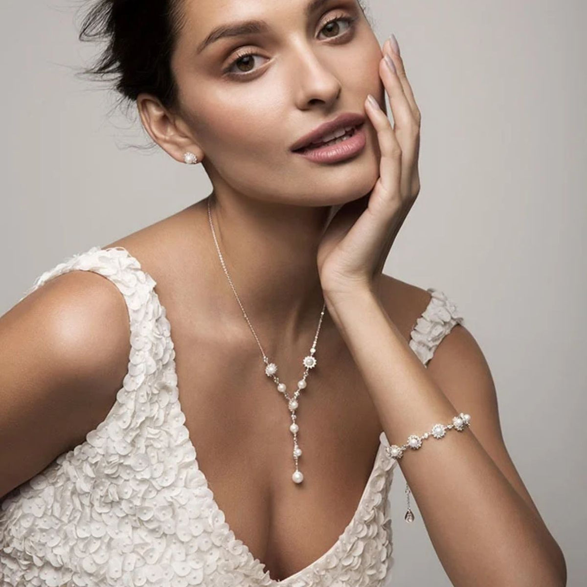 Beautifully classic, this stunning silver station bracelet will complement any attire. Nine luminous, white pearls sit centred in the flower inspired sunbursts, surrounded by a halo of shimmering clear, round crystals.