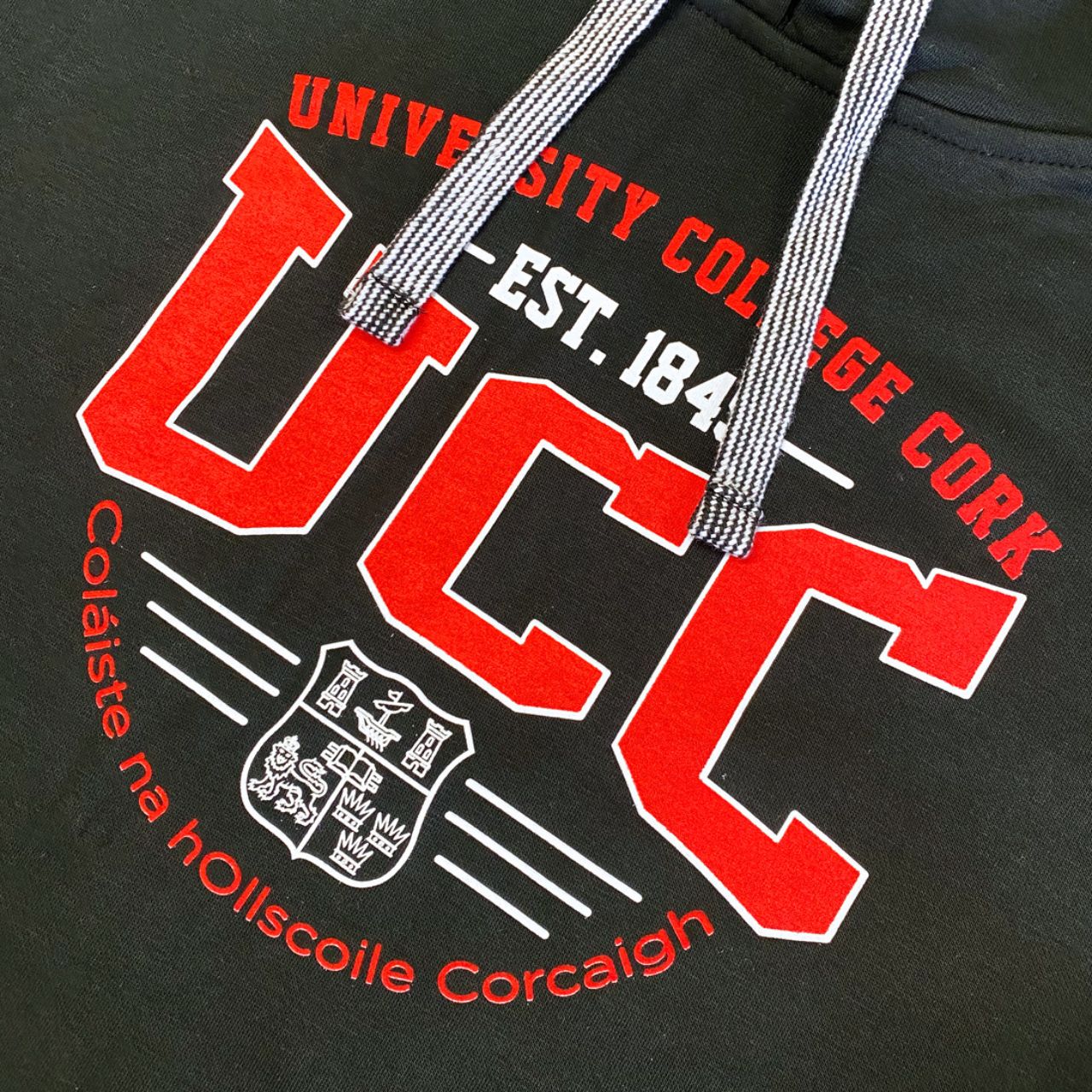 This UCC College Hoodie Est 1845 - Black is an official addition to the collection. Its relaxed fit showcases a printed UCC crest, UCC back neck label, contrasting draw strings, and a pocket with a UCC woven label.