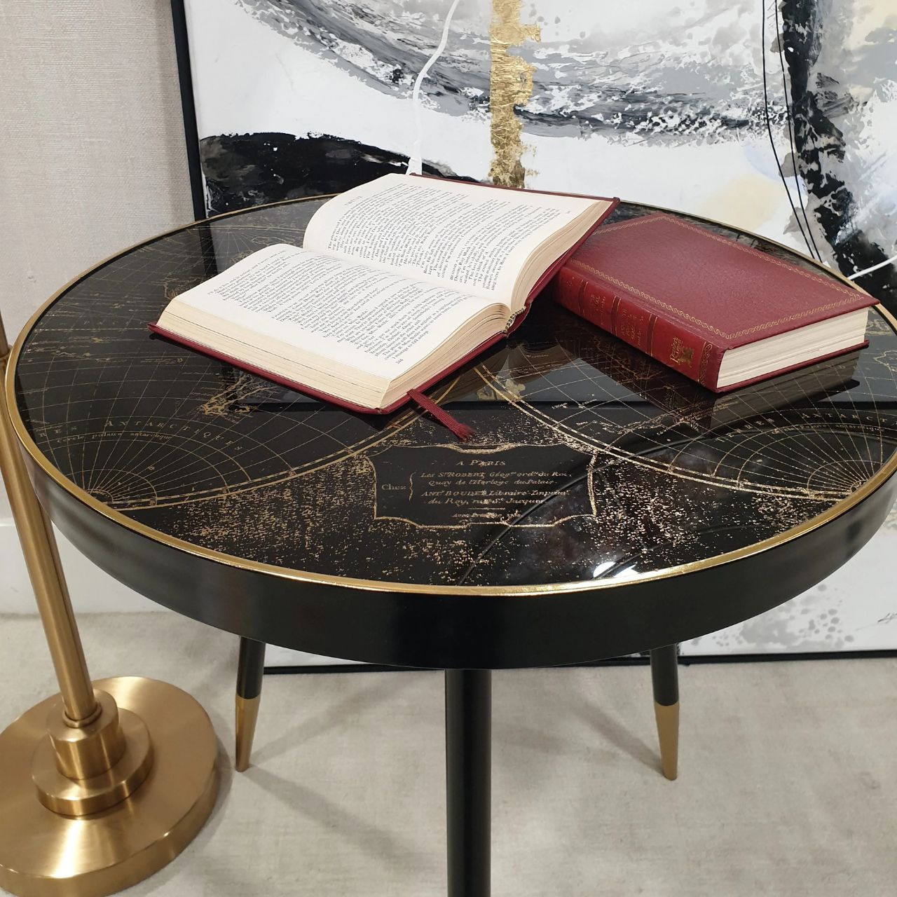 Black painted surround and leg with gold tip, 60 cm diameter side table with black &amp; antiqued gold world map pattern top with acrylic overlay. Can be styled solo or as part of a collaboration with the Palm, Bellatrix &amp; Vega side tables for the ultimate styling effect.
