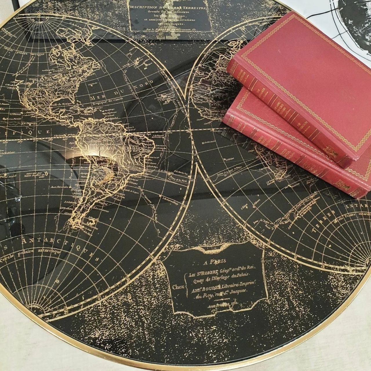 Black painted surround and leg with gold tip, 60 cm diameter side table with black &amp; antiqued gold world map pattern top with acrylic overlay. Can be styled solo or as part of a collaboration with the Palm, Bellatrix &amp; Vega side tables for the ultimate styling effect.