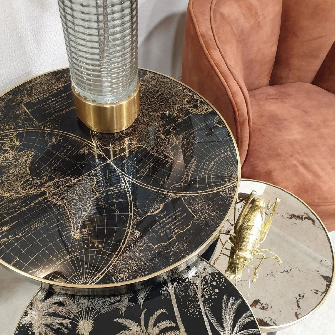 Black painted surround and leg with gold tip, 60 cm diameter side table with black &amp; antiqued gold world map pattern top with acrylic overlay. Can be styled solo or as part of a collaboration with the Palm, Bellatrix &amp; Vega side tables for the ultimate styling effect.