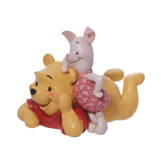 Winnie the Pooh & Piglet Figurine by Jim Shore  "Forever Friends" Best friends Piglet and Pooh Bear relax together in this charming Disney creation. A colourful ode to love and friendship, the pair look dashing in classic Jim Shore design. Smiling, they celebrate the 45th anniversary of Winnie the Pooh.