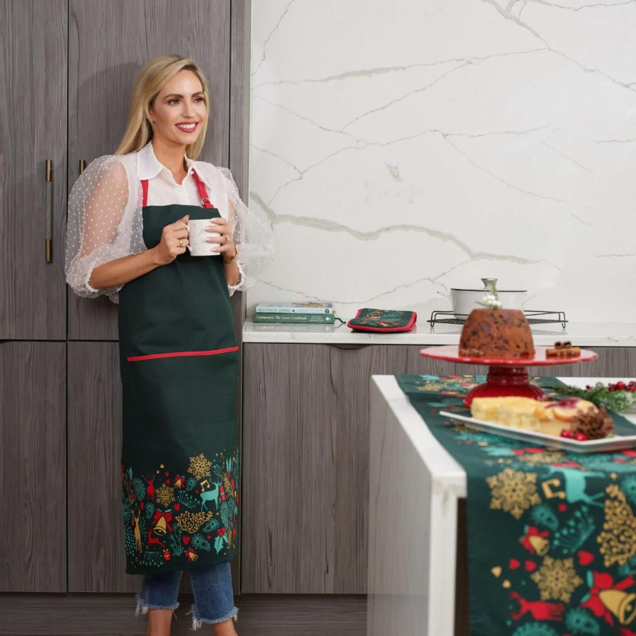 A Christmas Wish Apron by Mindy Brownes Interiors  A beautiful apron finished in forest green with a Christmas design that depicts some of Christmas' key elements, such as reindeer, presents, music notes, and more.  A stylish, yet practical way to avoid any outfit mishaps while baking and cooking this Christmas season.