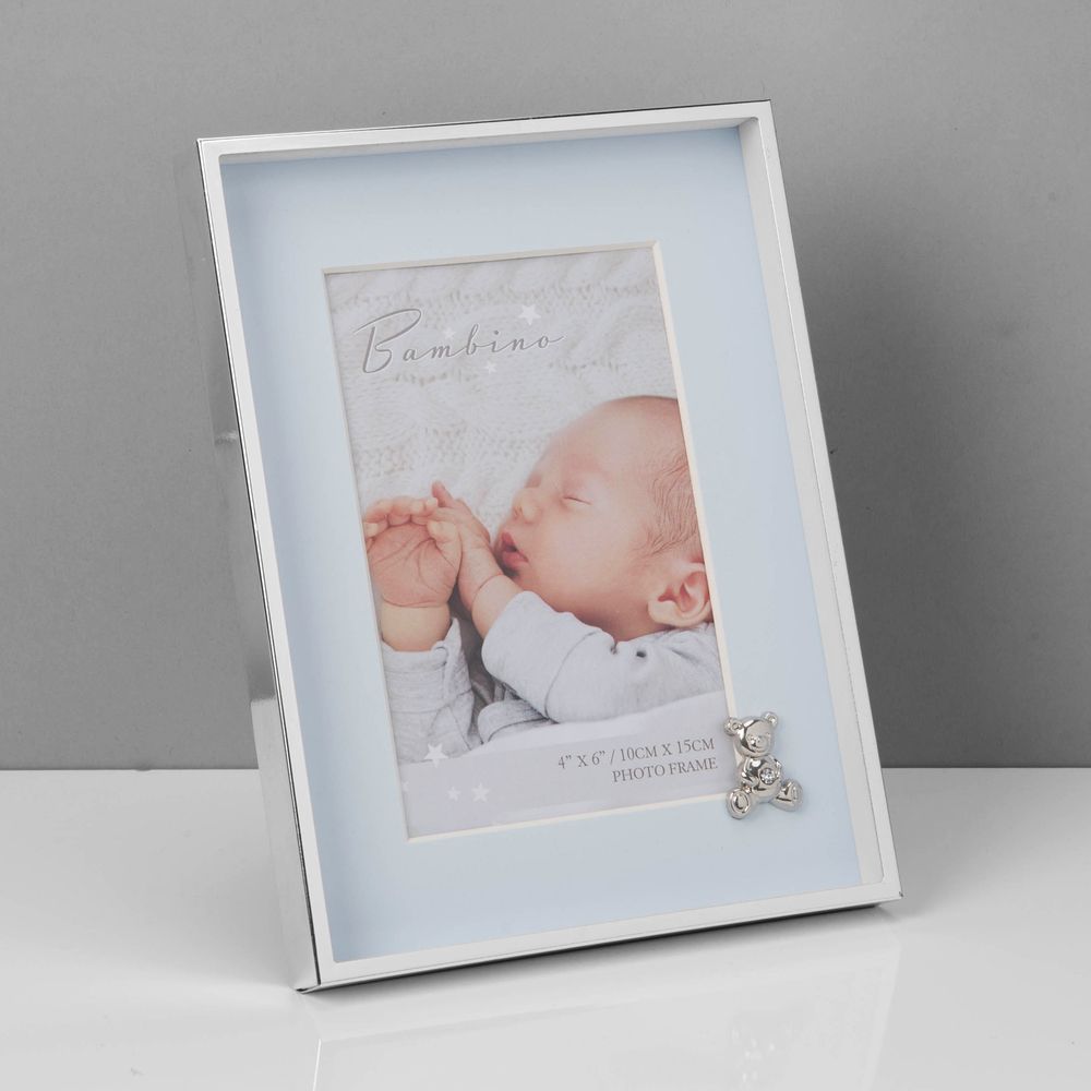 Bambino Silver Finish Frame - Teddy Blue Mount 4" x 6"  A gorgeous 4" x 6" (10 x 15 cm) nickel plated silver finish BAMBINO BY JULIANA® photo frame with a blue mount. The photo frame is embellished with a crystal finished silver teddy bear icon. Complete with a standing strut.