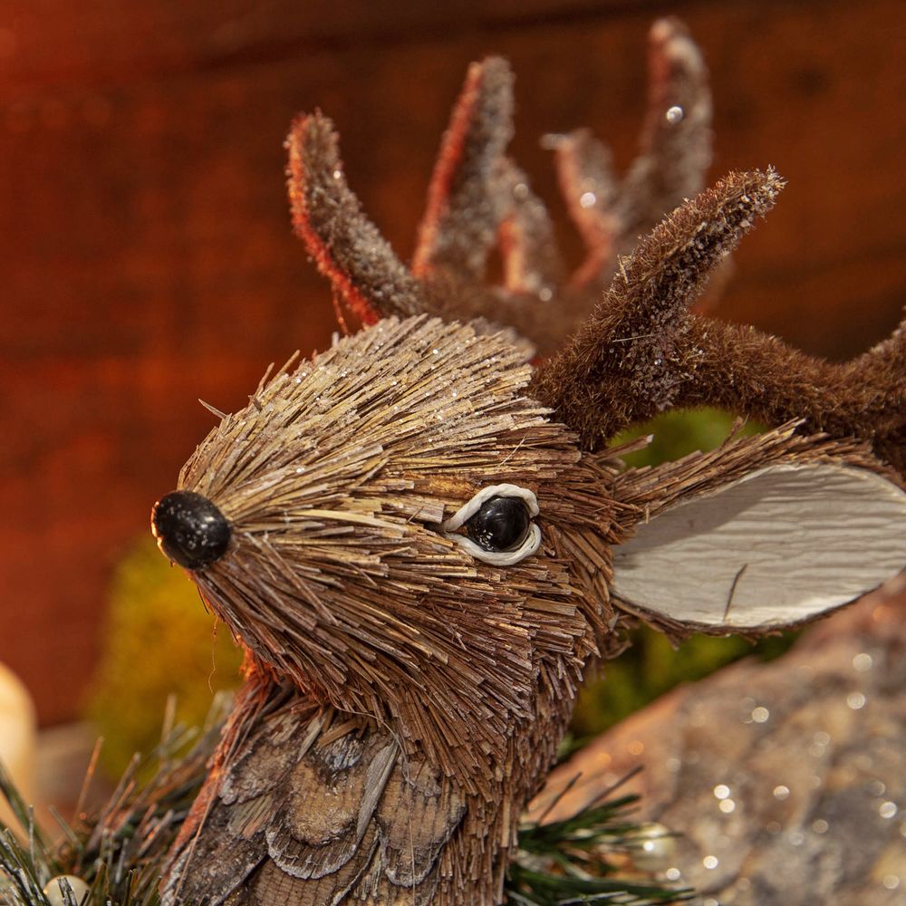 Christmas Sitting Reindeer Ornament  Create a rustic and comforting Christmas woodland decor theme with this handmade straw reindeer figurine. From the Enchanted Forest collection by Santa's Workshop - create your own winter wonderland.