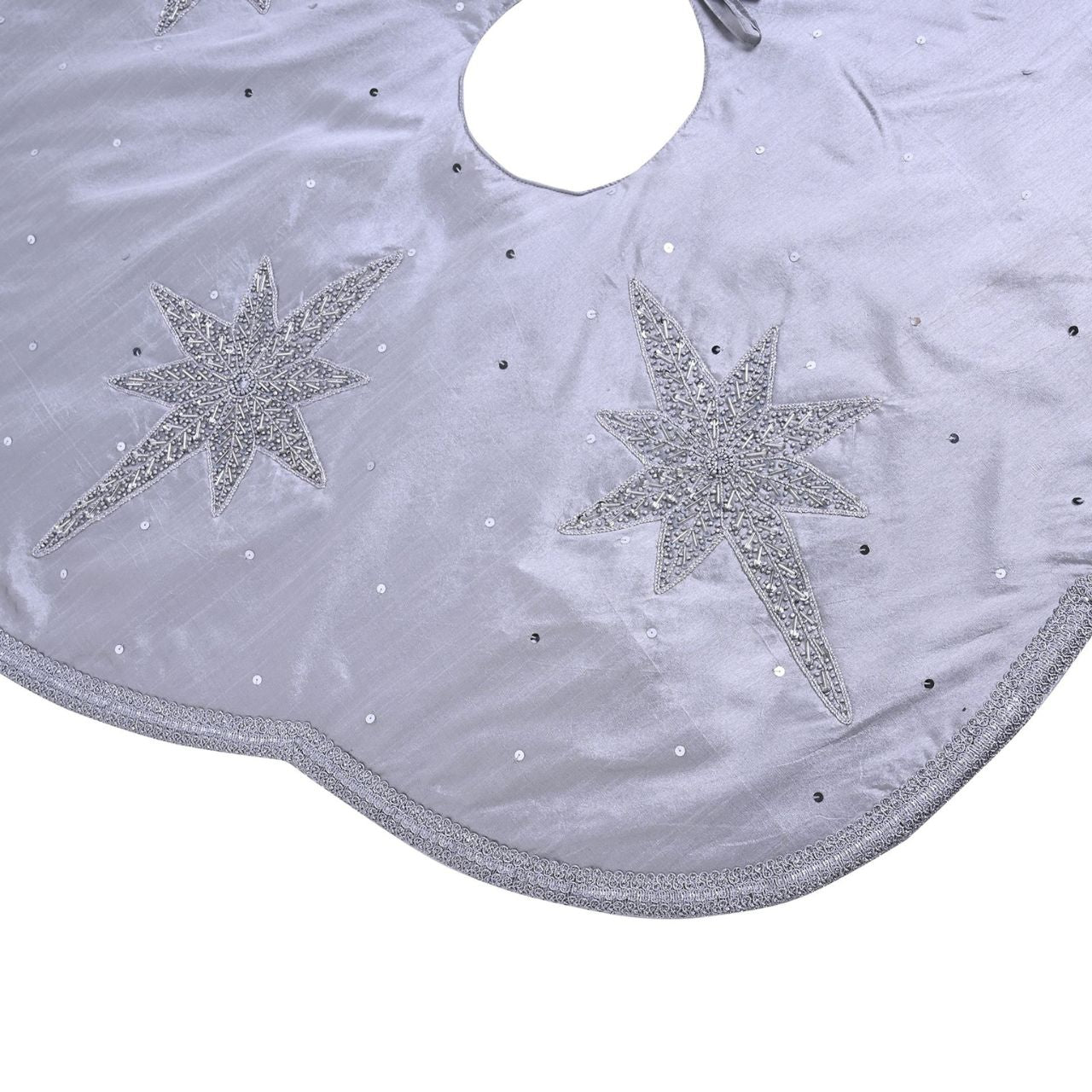 Christmas Tree Skirt with Scalloped Edge Silver Star Hand Embellished  A silver star hand embellished Christmas tree skirt with scalloped edge.  This standout accessory wraps itself around Christmas trees to accentuate its decoration.