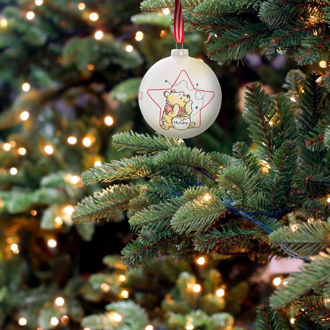 Christmas Bauble Disney Winnie The Pooh  Winnie the Pooh dreams about honey all day and this cute design shows that it is no exception at Christmas time. Sometimes the smallest things take up the most room in your heart and this glass bauble is the perfect example.