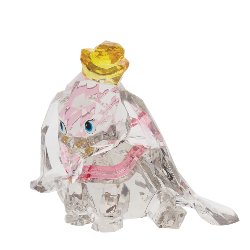 Dumbo Facets Figurine  This "gem cut" acrylic sculpture reflects the ninth wonder of the universe. The world's only flying elephant. Dumbo is already for his circus debut with his yellow hat and pink collar. Presented in a branded window gift box.