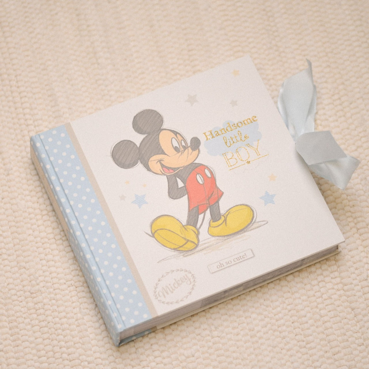 Disney Magical Beginnings Photo Album 4" x 6" Mickey Mouse  Add a touch of magic to your every day with this Magical Beginnings Photo Album.  As part of our range of classic Disney illustration giftware, this photo album displays a beautiful depiction of the classic Disney character, Mickey Mouse, 'Handsome Little Boy' gold glitter lettering, space for fifty 4" x 6" photos, personalisable title page and a blue bow closure.